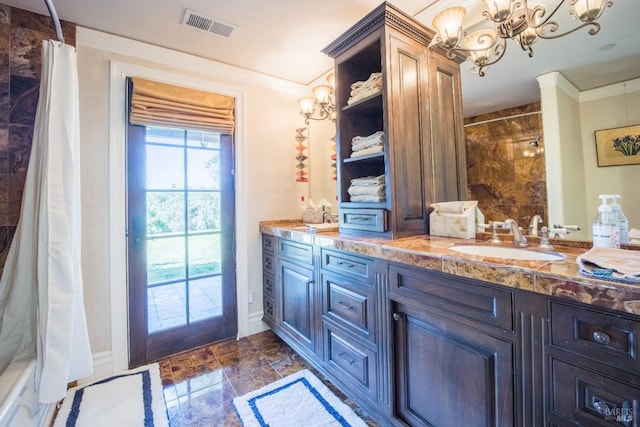 bathroom with ornamental molding, vanity, a chandelier, and walk in shower