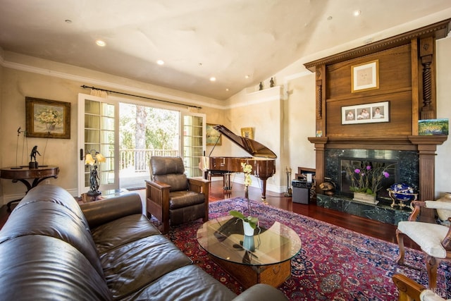 living room with vaulted ceiling, a premium fireplace, and hardwood / wood-style floors