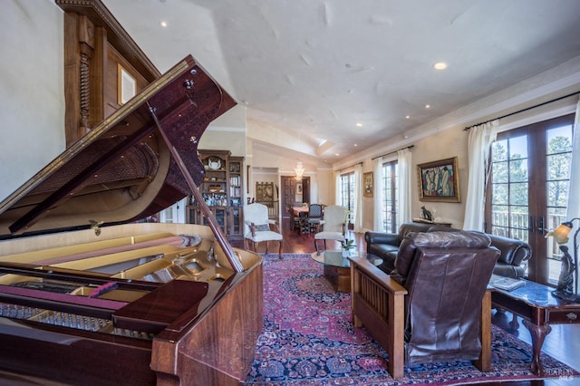 living room with hardwood / wood-style flooring, ornamental molding, lofted ceiling, and french doors