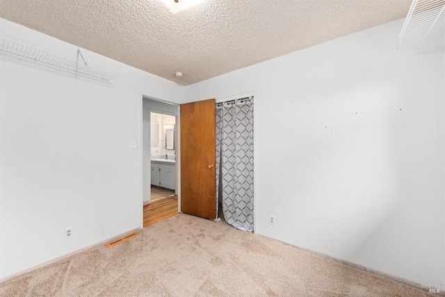 carpeted empty room with a textured ceiling