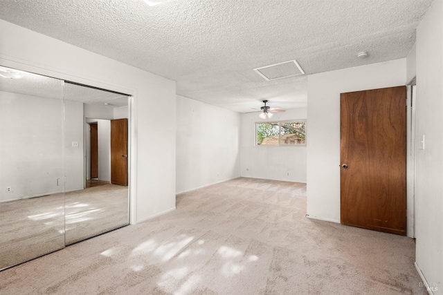 spare room featuring light carpet and a textured ceiling