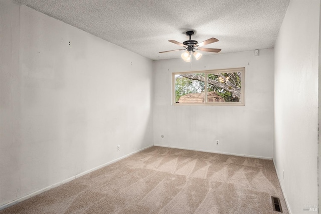 carpeted spare room with ceiling fan and a textured ceiling