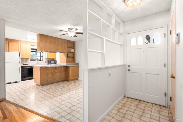 kitchen with ceiling fan, a kitchen breakfast bar, white refrigerator, a textured ceiling, and kitchen peninsula