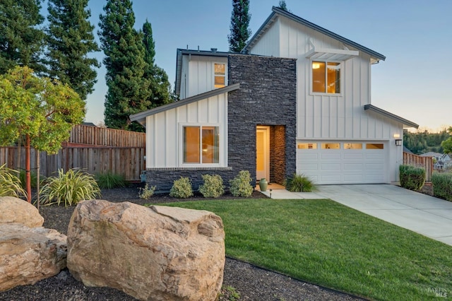 view of front of property with stone siding, board and batten siding, concrete driveway, and fence