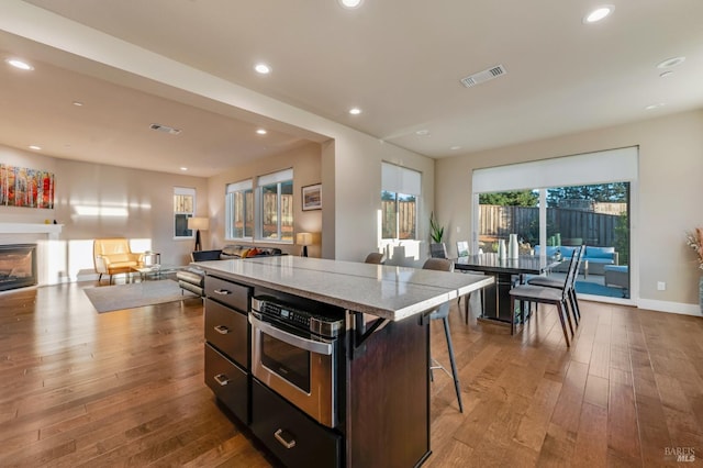 2228 Chateau Ct, Santa Rosa, CA 95404 - kitchen with light wood-style flooring, a kitchen island, visible vents, open floor plan, and a kitchen bar
