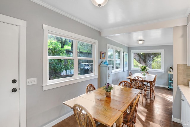 dining space with baseboards, dark wood-style flooring, and crown molding