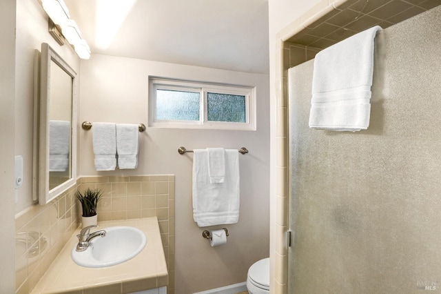full bathroom featuring vanity, a shower with door, and toilet