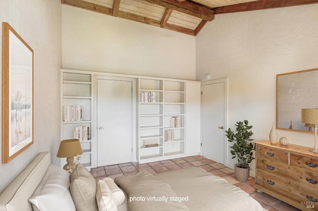 tiled bedroom with beamed ceiling and high vaulted ceiling
