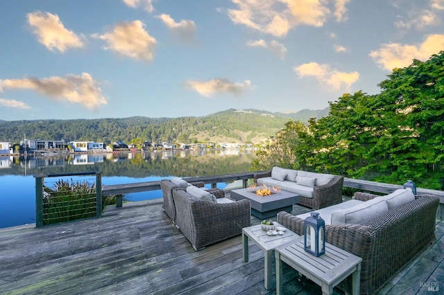 deck with a water and mountain view and an outdoor living space with a fire pit