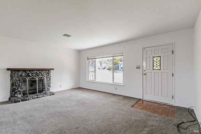 unfurnished living room featuring carpet floors and a stone fireplace