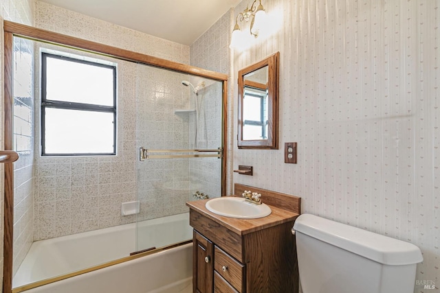 full bathroom featuring toilet, vanity, and combined bath / shower with glass door