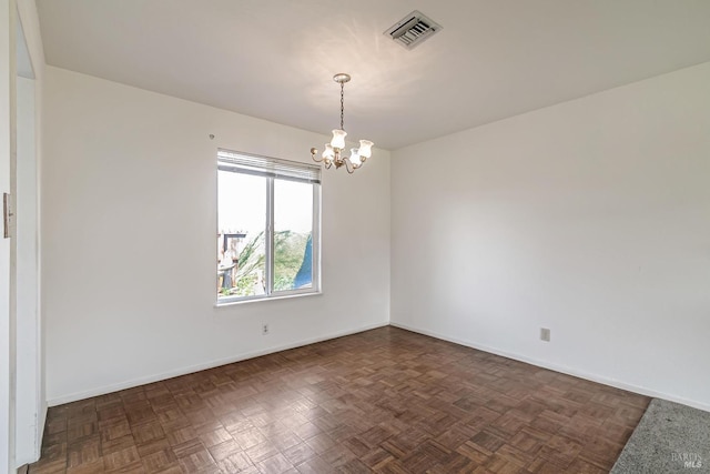 empty room featuring a chandelier and dark parquet floors