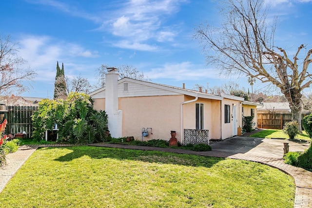 view of side of home featuring a patio area and a yard