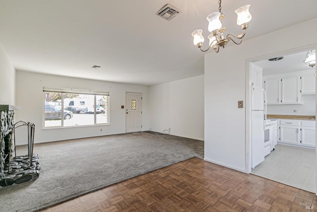 unfurnished living room featuring a chandelier and light parquet floors