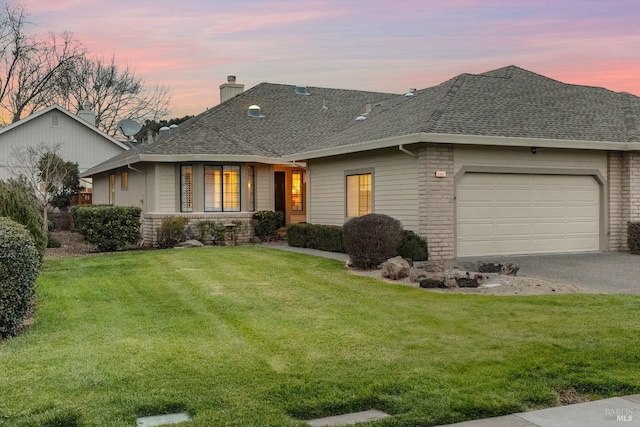 view of front of home featuring a garage, a shingled roof, a chimney, and a lawn