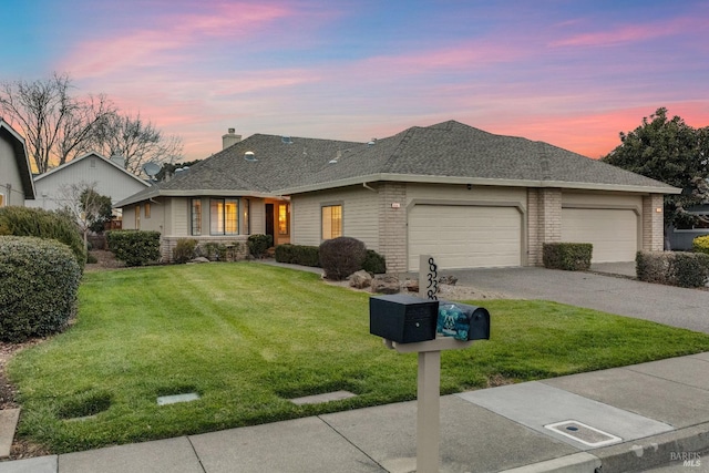 ranch-style home featuring a garage, driveway, a lawn, roof with shingles, and a chimney