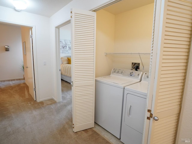 laundry area with washing machine and dryer and light carpet