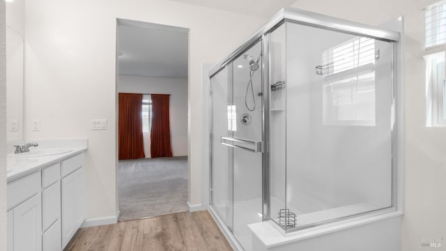 bathroom featuring vanity, wood finished floors, and a stall shower