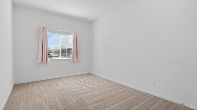 carpeted spare room featuring baseboards