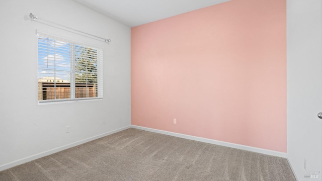 carpeted empty room featuring baseboards