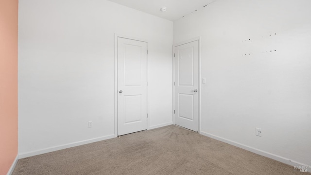 unfurnished bedroom with carpet floors and baseboards