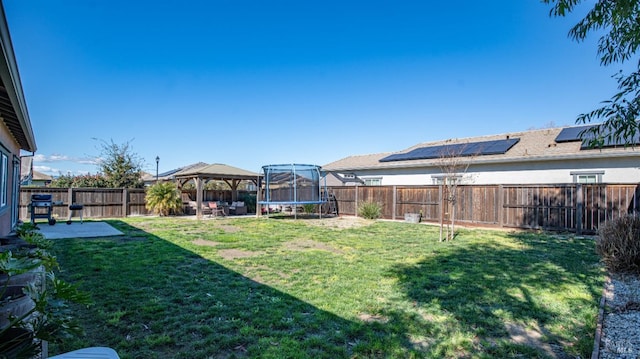 view of yard featuring a gazebo, a fenced backyard, a trampoline, and a patio