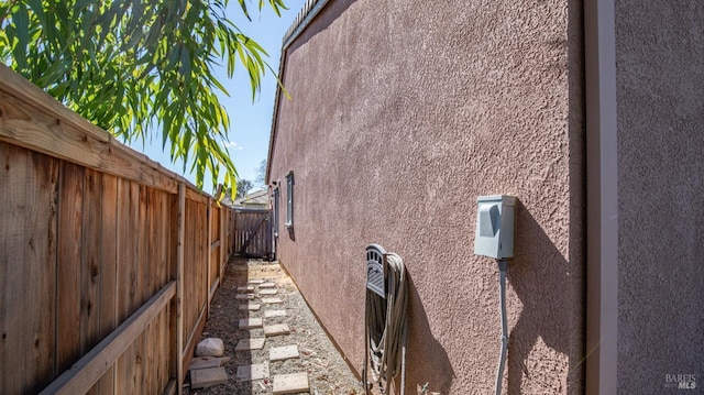 view of side of property featuring a fenced backyard and stucco siding