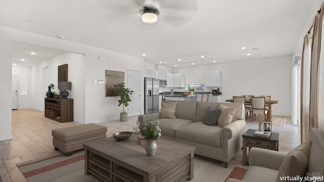 living area with baseboards, recessed lighting, a ceiling fan, and light wood-style floors