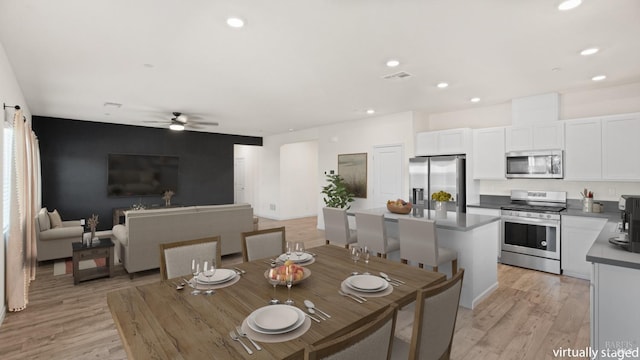 dining room featuring light wood-style floors, a ceiling fan, recessed lighting, and visible vents