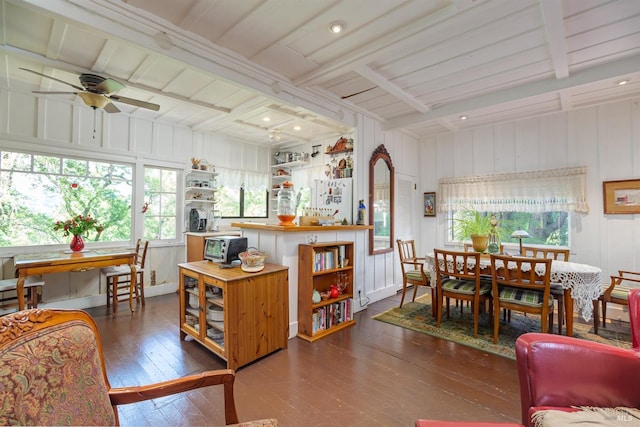 dining space with beam ceiling, dark wood-type flooring, and ceiling fan