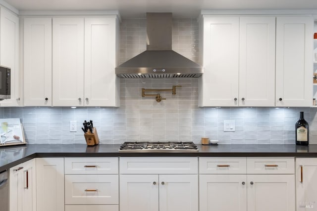 kitchen featuring appliances with stainless steel finishes, dark countertops, and wall chimney exhaust hood