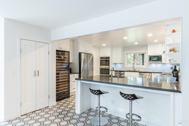 kitchen with dark countertops, decorative backsplash, stainless steel appliances, and a sink