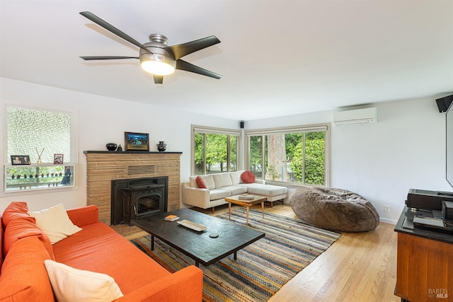 living room with a wall unit AC, ceiling fan, and wood finished floors