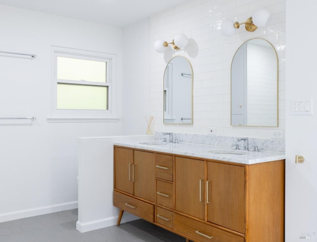 full bathroom featuring double vanity, a sink, and baseboards