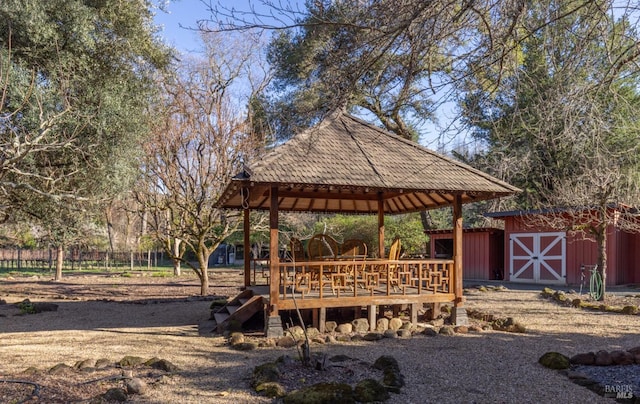 view of community with an outdoor structure, a wooden deck, a gazebo, and a storage shed