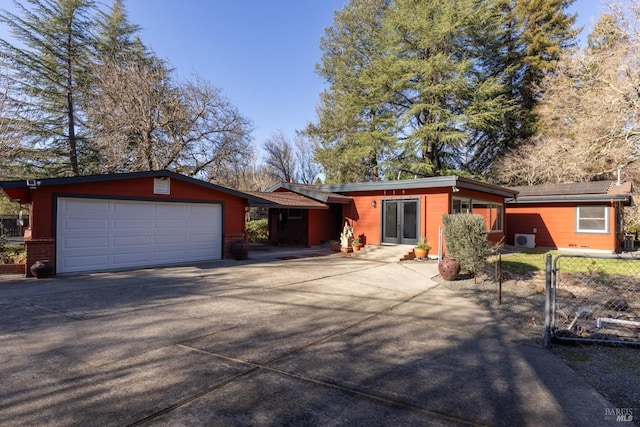 view of front of home featuring a garage, concrete driveway, and fence