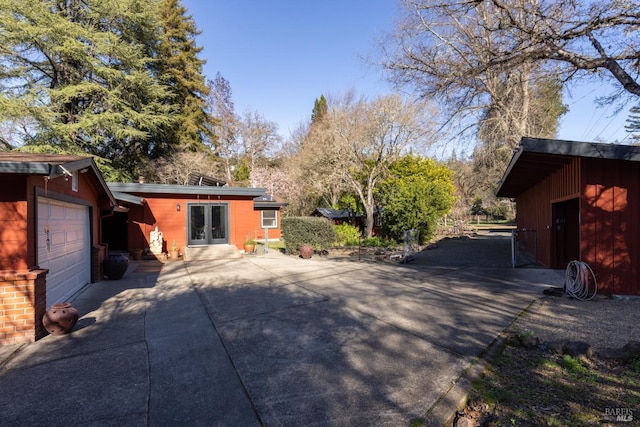 view of side of property featuring a garage and french doors