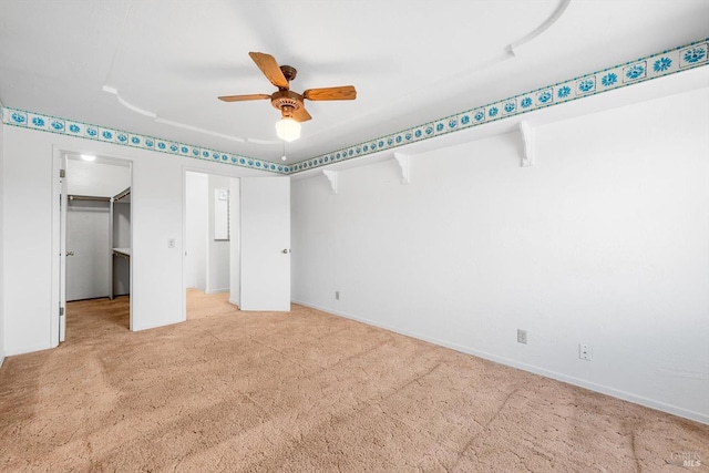 unfurnished bedroom with a walk in closet, light colored carpet, and ceiling fan