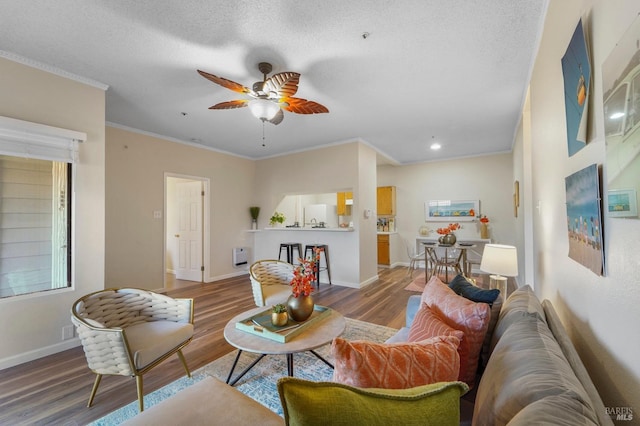 living area featuring ornamental molding, wood finished floors, and baseboards