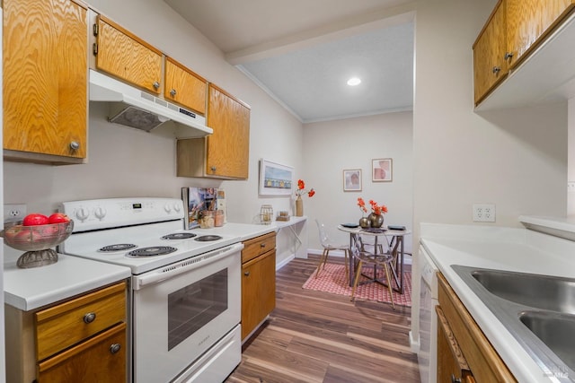 kitchen featuring white appliances, dark wood-style flooring, light countertops, crown molding, and under cabinet range hood