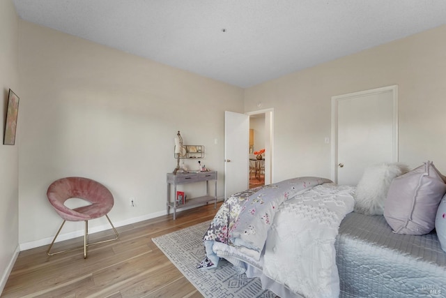 bedroom featuring wood finished floors and baseboards