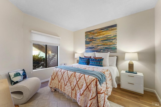 bedroom with baseboards and wood finished floors