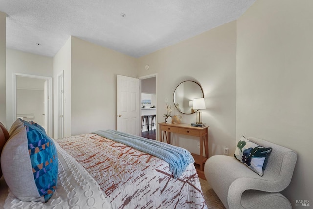 bedroom with a textured ceiling and wood finished floors