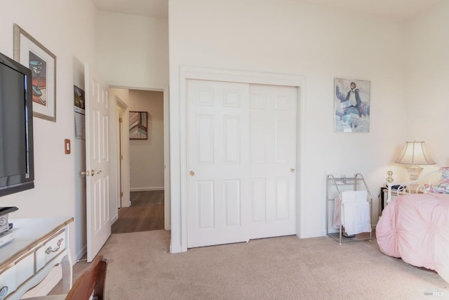 bedroom featuring light colored carpet and a closet