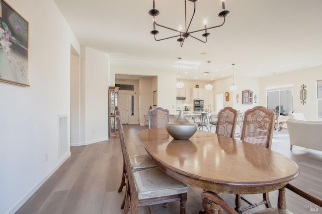 dining room featuring light hardwood / wood-style floors and a notable chandelier