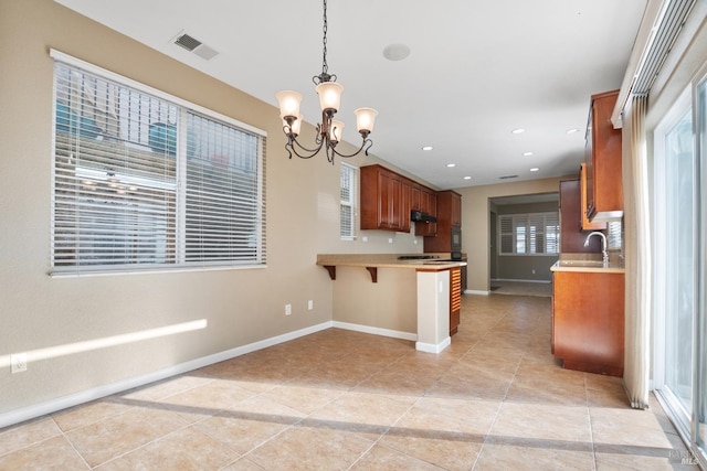 kitchen with a chandelier, a breakfast bar, light tile patterned floors, decorative light fixtures, and kitchen peninsula