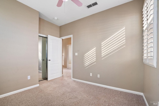 unfurnished bedroom featuring light carpet, ceiling fan, and a closet