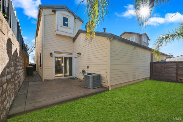 back of house with cooling unit, a lawn, and a patio area