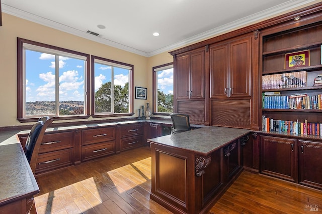 office area with built in desk, ornamental molding, and dark hardwood / wood-style floors