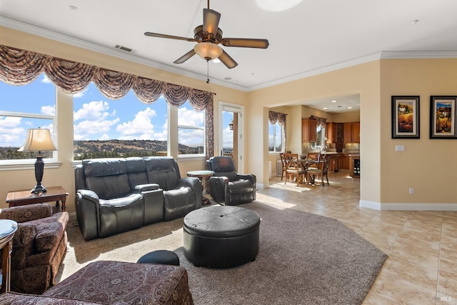 tiled living room with ornamental molding and ceiling fan